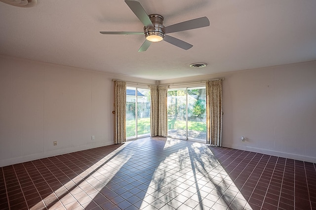 tiled spare room with ceiling fan