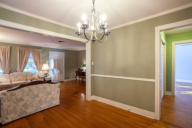 interior space with hardwood / wood-style flooring, crown molding, and a notable chandelier