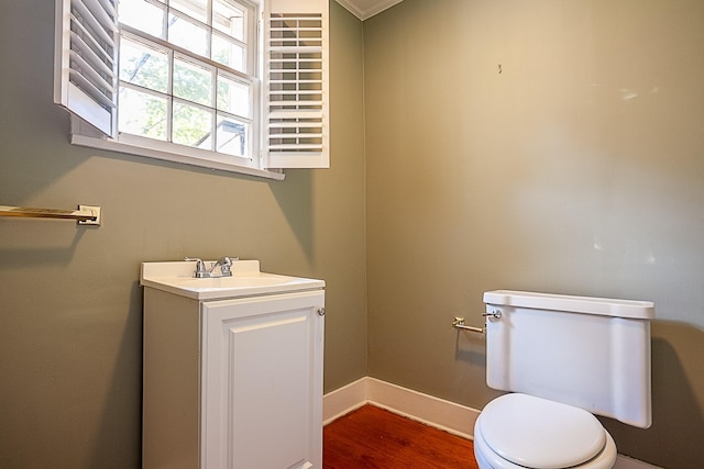 bathroom featuring vanity, hardwood / wood-style flooring, toilet, and ornamental molding