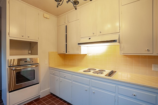 kitchen featuring decorative backsplash, white cabinetry, oven, and white gas cooktop