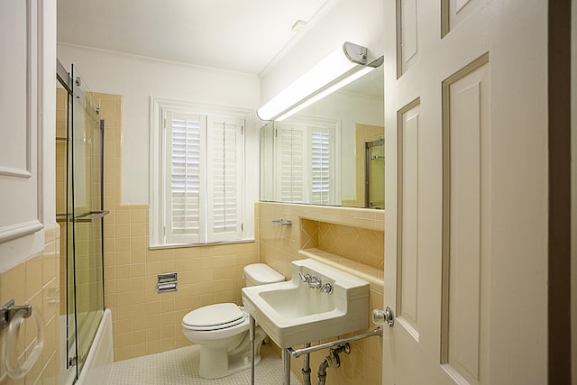 bathroom featuring tile patterned flooring, toilet, ornamental molding, tile walls, and walk in shower