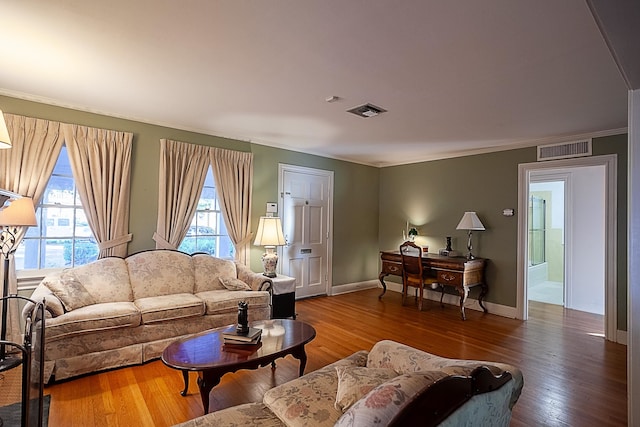 living room featuring hardwood / wood-style floors, a wealth of natural light, and ornamental molding