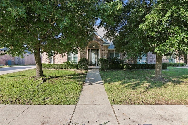 obstructed view of property with a front lawn