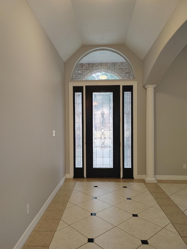 tiled foyer entrance featuring decorative columns and lofted ceiling