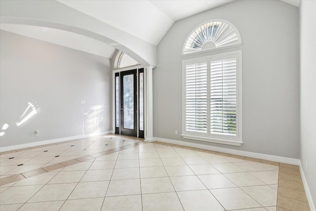 tiled foyer with decorative columns, lofted ceiling, and a healthy amount of sunlight