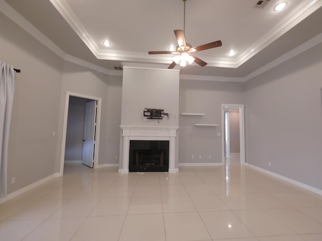 unfurnished living room featuring crown molding, a tray ceiling, and light tile patterned floors