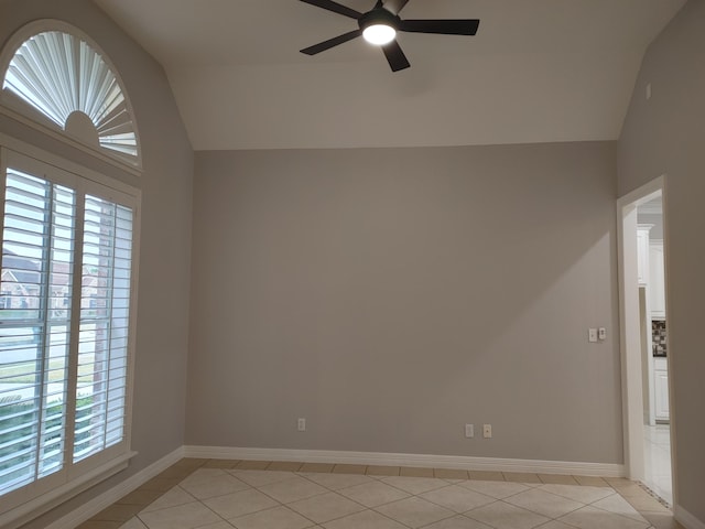 spare room featuring light tile patterned floors, vaulted ceiling, and ceiling fan