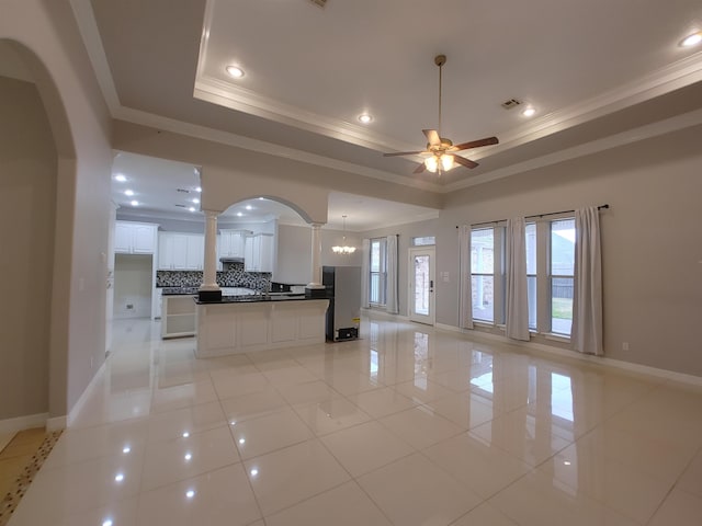 kitchen featuring backsplash, a tray ceiling, white cabinets, and light tile patterned flooring