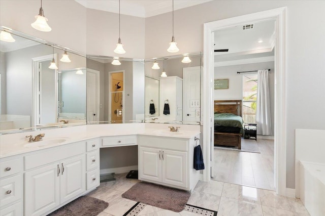 bathroom with tile patterned flooring, vanity, ornamental molding, and a washtub