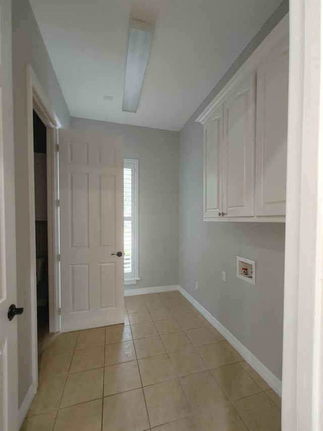 washroom featuring cabinets, hookup for a washing machine, and light tile patterned floors