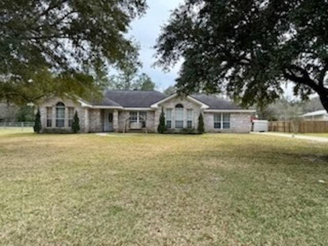 ranch-style house with a front lawn and fence