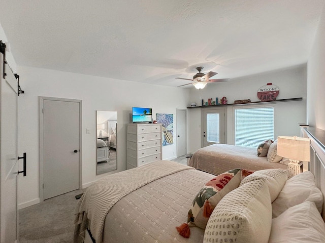 carpeted bedroom featuring a ceiling fan, access to outside, baseboards, and a barn door