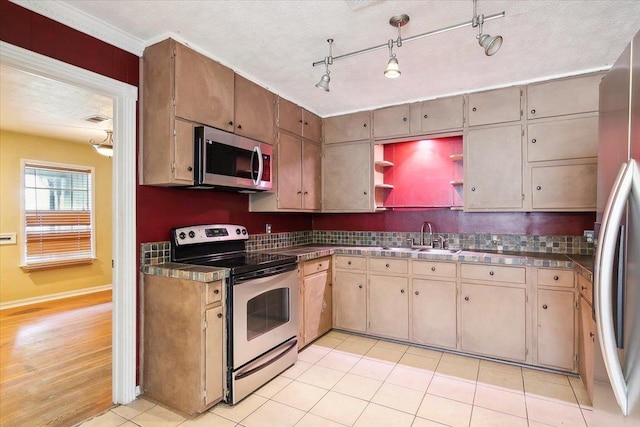 kitchen featuring sink, stainless steel appliances, a textured ceiling, light tile patterned floors, and ornamental molding