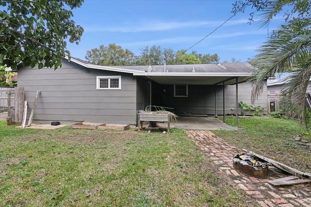 rear view of house with a patio and a lawn