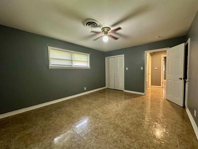 unfurnished bedroom with ceiling fan and a closet