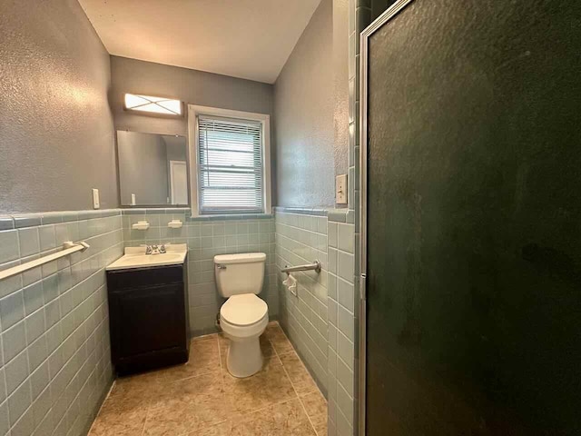 bathroom with vanity, tile patterned flooring, toilet, tile walls, and walk in shower