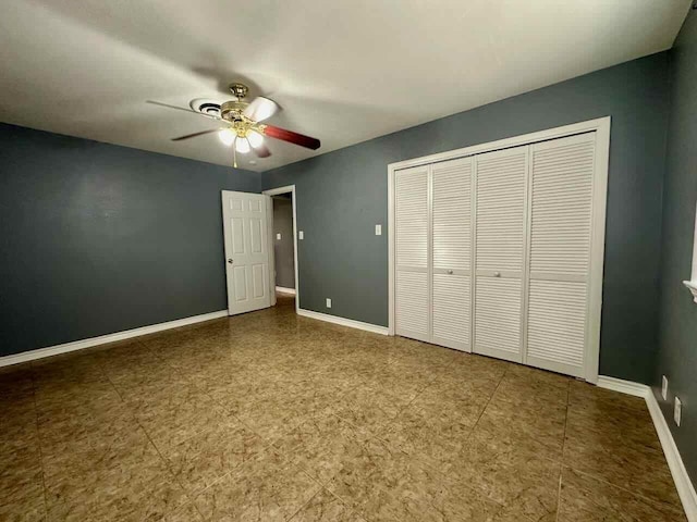 unfurnished bedroom with ceiling fan and a closet