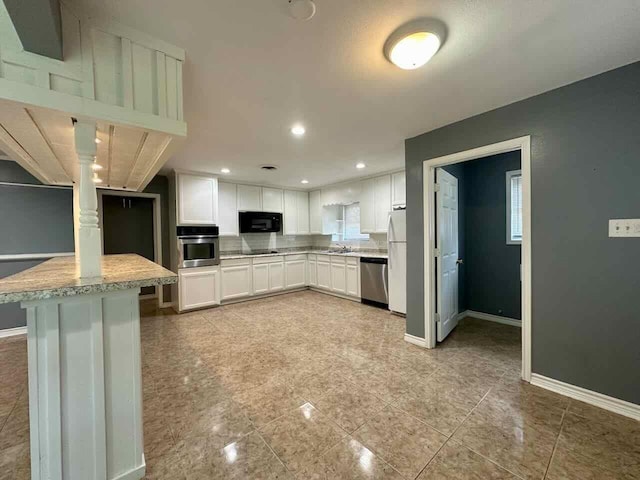 kitchen featuring black appliances, light stone counters, white cabinets, and sink