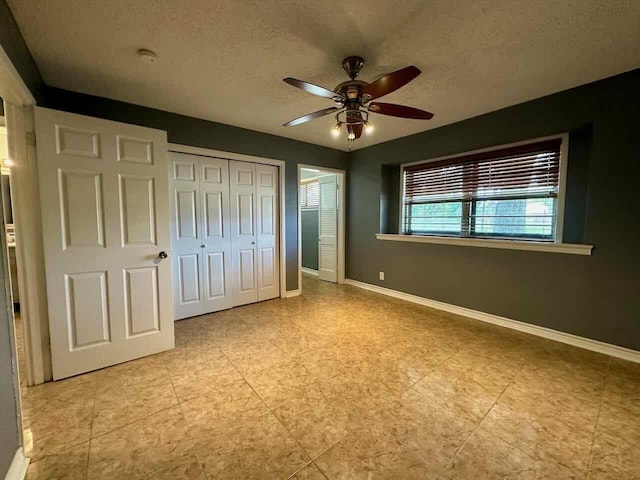 unfurnished bedroom featuring a textured ceiling, a closet, and ceiling fan