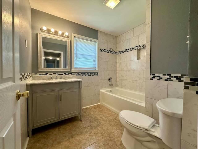 full bathroom featuring tile patterned floors, vanity, tile walls, toilet, and tiled shower / bath