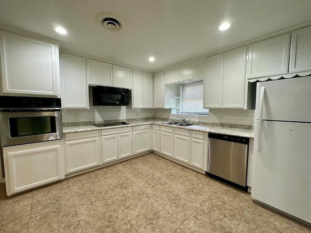 kitchen featuring light stone counters, sink, white cabinets, and black appliances