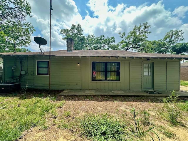 rear view of house with a lawn and cooling unit