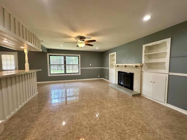 unfurnished living room featuring ceiling fan and a fireplace