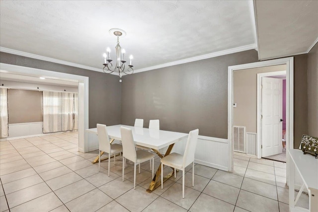 dining area featuring an inviting chandelier, ornamental molding, and light tile patterned flooring