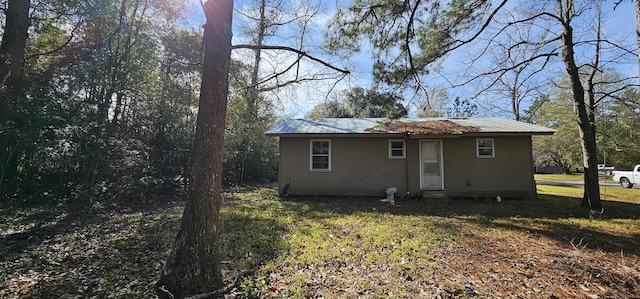 rear view of property featuring a lawn