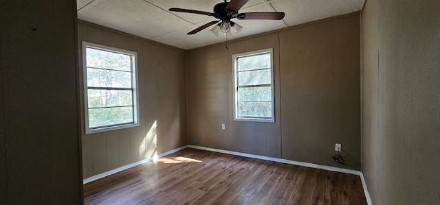 unfurnished room featuring ceiling fan, a healthy amount of sunlight, hardwood / wood-style floors, and ornamental molding