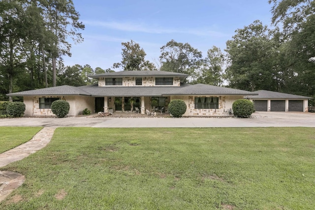 1025 Creek Bend Dr, Jasper, TX 75951 - prairie-style house with stone siding, concrete driveway, a front yard, and a porch
