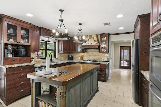 1025 Creek Bend Dr, Jasper, TX 75951 - kitchen with custom range hood, stainless steel gas cooktop, a chandelier, backsplash, and open shelves