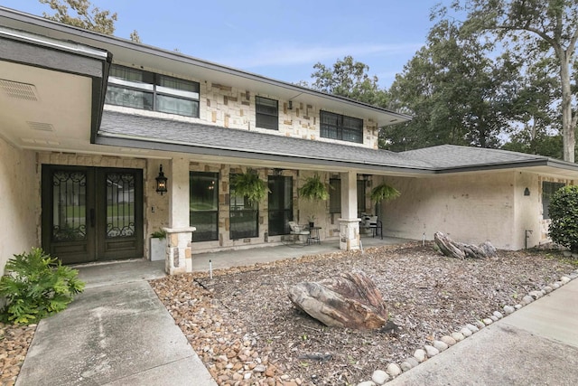 1025 Creek Bend Dr, Jasper, TX 75951 - property entrance with french doors, a shingled roof, and covered porch