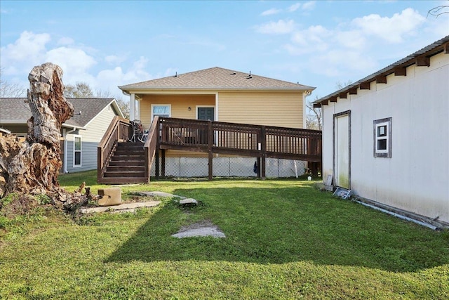 rear view of property with a lawn, a deck, and stairs