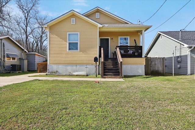 bungalow-style home with fence, a front lawn, and central AC