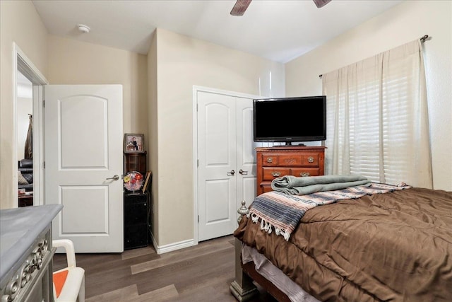 bedroom featuring dark wood-style floors, ceiling fan, a closet, and baseboards