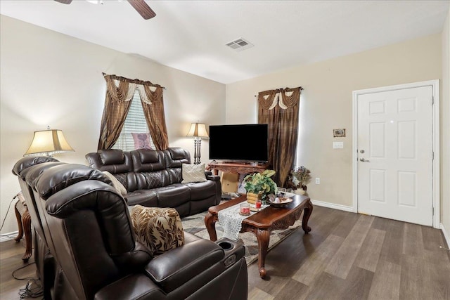 living area with baseboards, wood finished floors, visible vents, and a ceiling fan