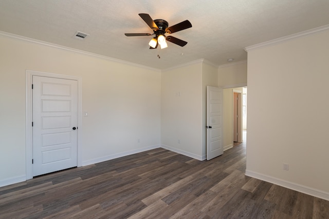 unfurnished room with dark wood-style flooring, visible vents, crown molding, and baseboards