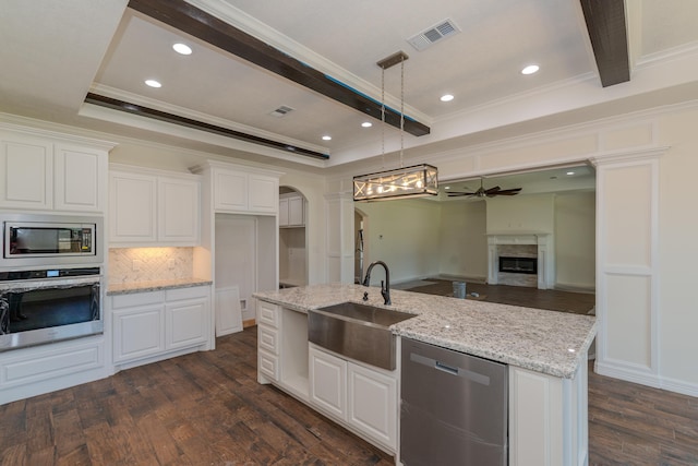 kitchen with arched walkways, a sink, visible vents, white cabinetry, and appliances with stainless steel finishes