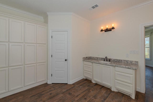 kitchen featuring a sink, visible vents, white cabinetry, ornamental molding, and dark wood finished floors