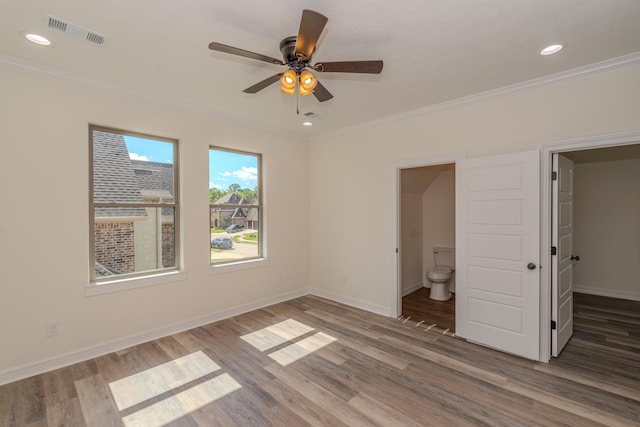 unfurnished bedroom featuring ornamental molding, wood finished floors, and visible vents