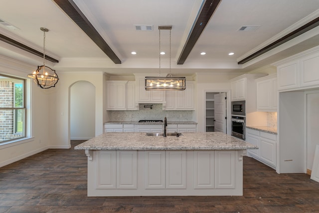 kitchen with stainless steel appliances, beamed ceiling, a sink, and white cabinetry