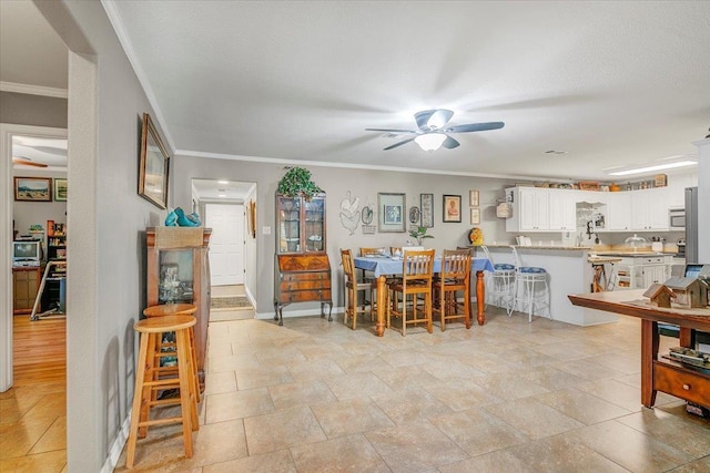 410 Christy Ln, Bridge City, TX 77611 - dining room with a ceiling fan, ornamental molding, and light stone finish flooring