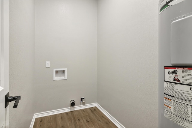 washroom with hookup for a washing machine, electric water heater, wood finished floors, laundry area, and baseboards