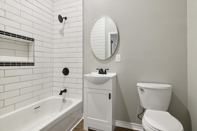 bathroom featuring bathing tub / shower combination, toilet, vanity, wood finished floors, and baseboards