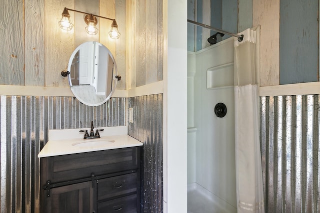 bathroom with a shower, vanity, and wallpapered walls