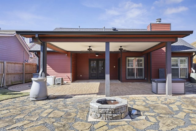 back of property featuring ceiling fan, a patio, an outdoor fire pit, fence, and french doors