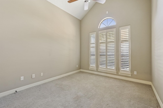 carpeted empty room with high vaulted ceiling, ceiling fan, and baseboards