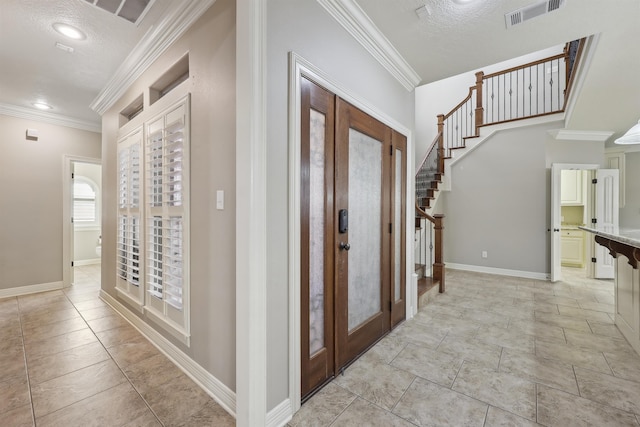 foyer entrance featuring ornamental molding, visible vents, stairway, and baseboards