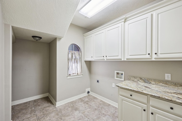 laundry area with a textured ceiling, hookup for a washing machine, baseboards, cabinet space, and electric dryer hookup